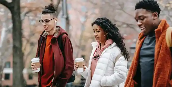 Três amigos caminhando segundo copos de café. Estudo bíblico sobre relacionamentos.